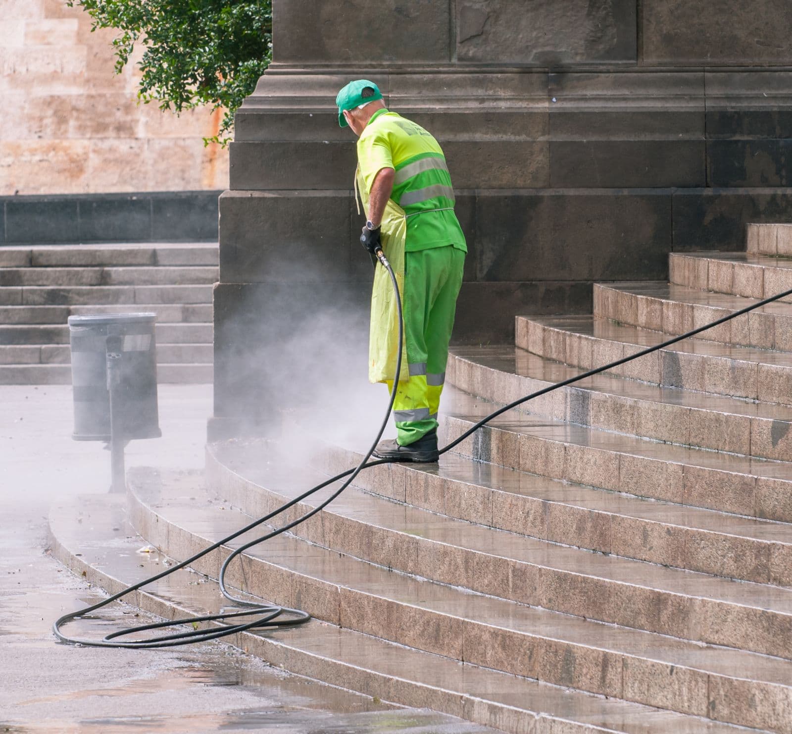 Worker pressure washing stone steps clean