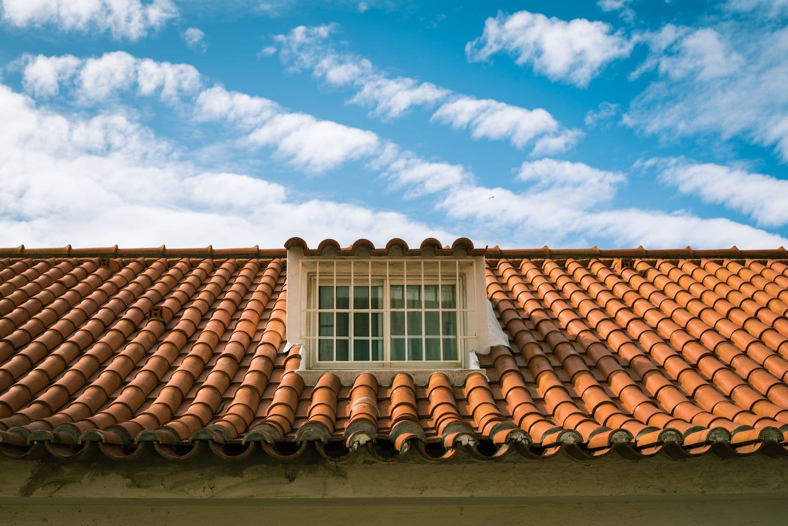 Terracotta tile roof with buildup along the eaves before cleaning